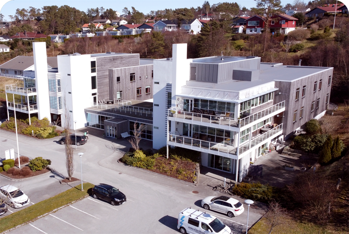 Luftfoto av Norheim sykehjem som viser hovedbygg og uteområde - Klikk for stort bilde