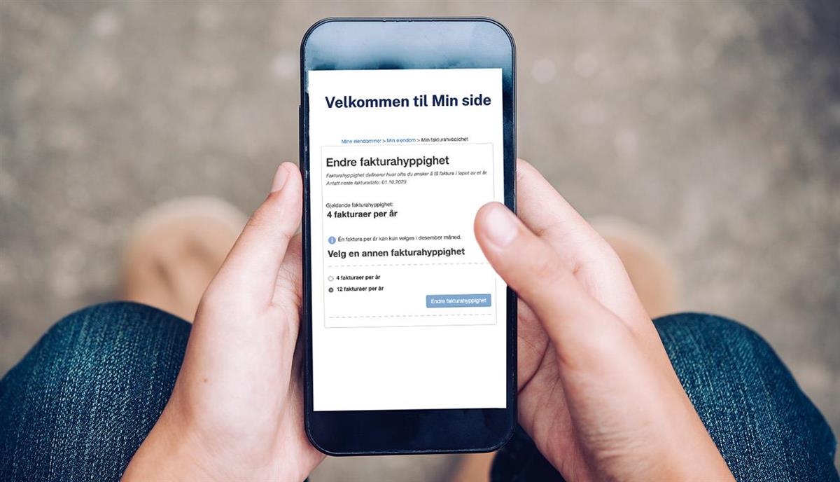 Bildet viser en hånd som holder mobiltelefon. På skjermen vises innstillinger for fakturahyppighet. Foto. - Klikk for stort bilde