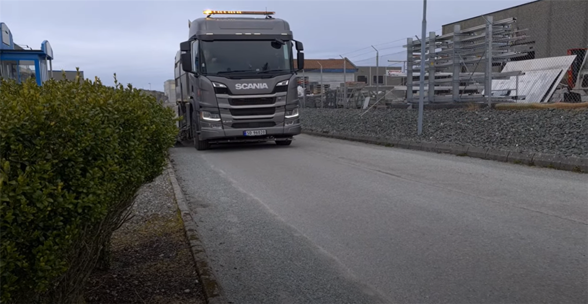 Feiebil som feier strøsand langs veien - Klikk for stort bilde