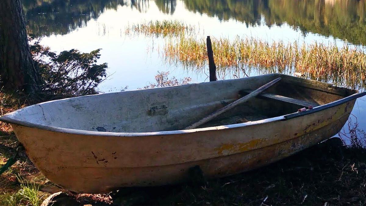 Bilde av en eldre jolle, båt som er parkert på land. - Klikk for stort bilde