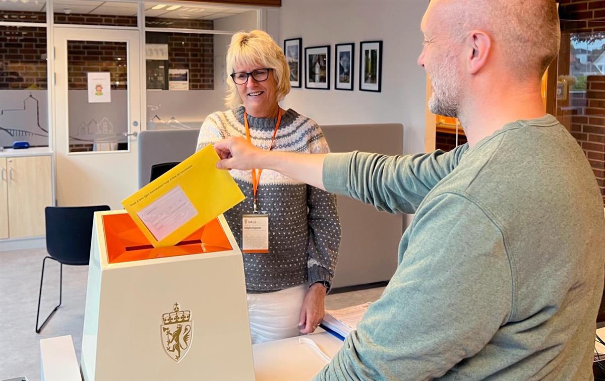 Bildet viser en mann som stemmer med stemmeseddel på Servicekontoret på Karmøy rådhus. - Klikk for stort bilde