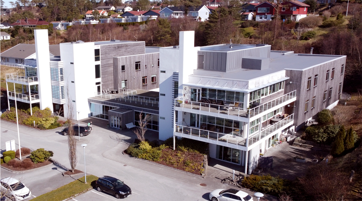 Luftfoto av Norheim sykehjem som viser hovedbygg og uteområde - Klikk for stort bilde
